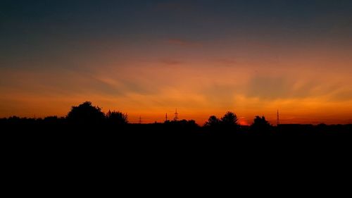 Scenic view of silhouette landscape against orange sky