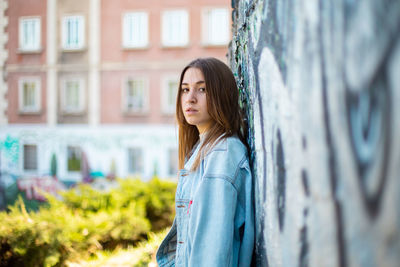Portrait of woman standing against wall in building