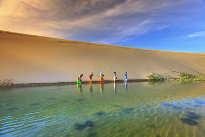 People enjoying in water against sky