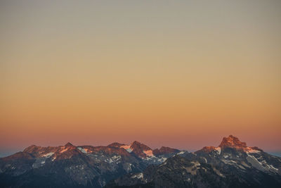 Scenic view of snowcapped mountains against sky at sunset