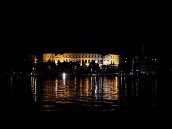 Illuminated buildings with waterfront at night