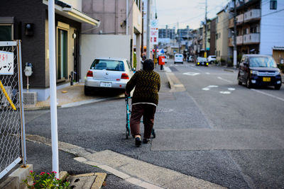 Rear view of woman walking on city street