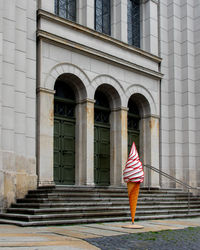 Rear view of woman standing at staircase of building