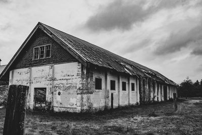 Abandoned house on field against sky