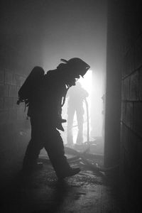 Full length of silhouette firefighters abandoned building