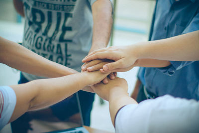 High angle of people joining hands 