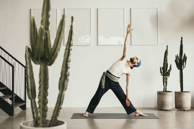 Male fitness instructor practicing yoga on exercise mat
