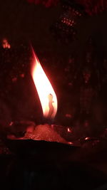 Close-up of lit candle in the dark