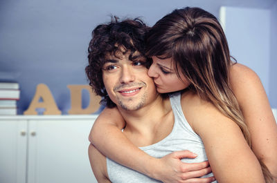 Close-up of loving couple embracing at home