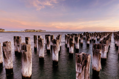 Panoramic view of wooden posts on sea against sky