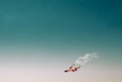 Low angle view of airshow against clear blue sky