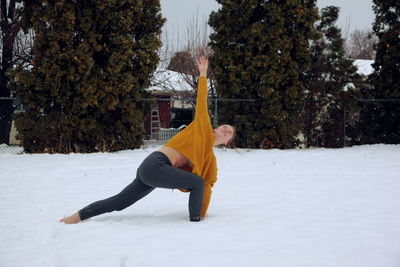 Woman standing on snow covered tree