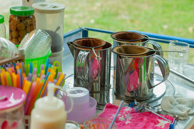 High angle view of strainers on jugs at outdoor table