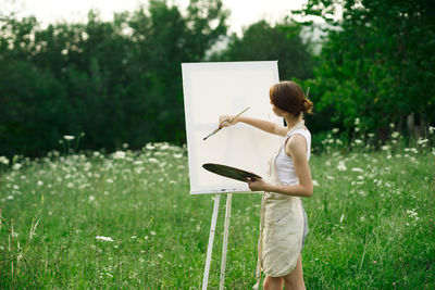 Man holding umbrella standing on field