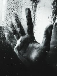 Digital composite image of hand on wet glass