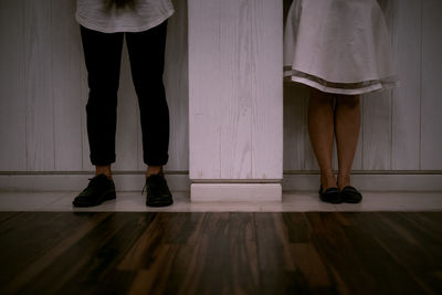 Low section of people standing on wooden floor