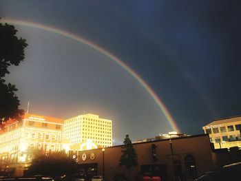 Rainbow over city against sky