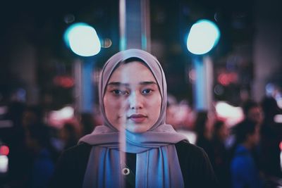 Portrait of young woman standing at night