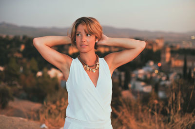 Young woman with hands in hair looking away on mountain