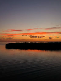 Scenic view of lake against romantic sky at sunset