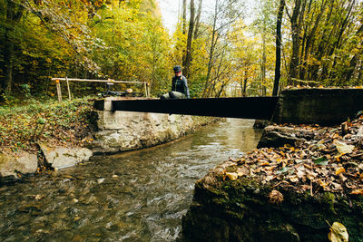 Rear view of man sitting on rock