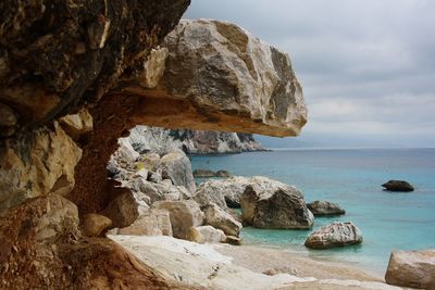 Rocks on sea shore against sky