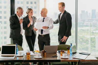 Men and woman using smart phone at table