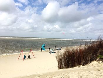 People on beach against sky