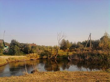 Scenic view of calm lake against clear blue sky