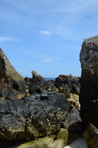 Rock formation on shore against sky