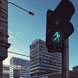 Low angle view of road sign against blue sky