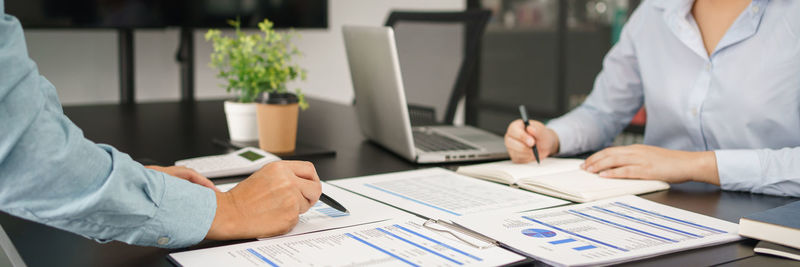 Midsection of business colleagues working at table