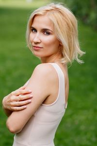 Portrait of young woman standing on field