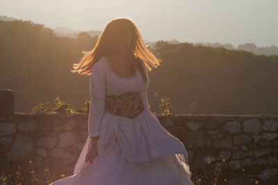 Woman standing on field against sky