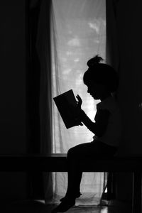 Side view of silhouette boy standing at home