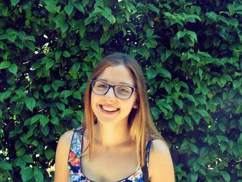 Portrait of happy woman against tree