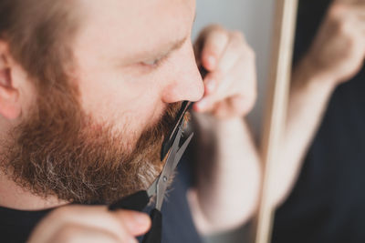 High angle view of man cutting mustache