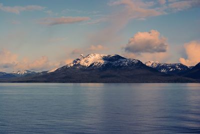 Scenic view of lake by mountains against sky during sunset