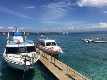 Boats sailing on sea against sky in city