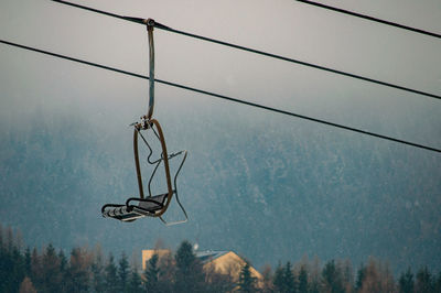 Low angle view of overhead cable car against sky