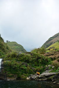 Scenic view of river and mountains against sky