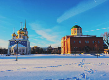 Building on snow covered land against blue sky