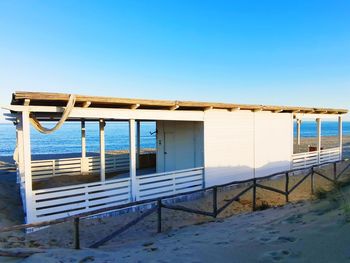 Built structure on beach against clear blue sky