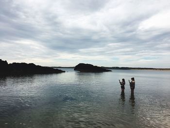 People standing on beach against sky