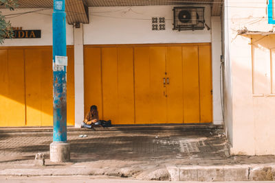 Woman sitting outside building