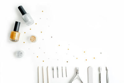 High angle view of bottles on table against white background