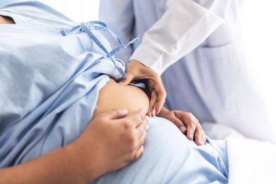 Midsection of woman lying on bed