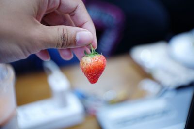 Close-up of hand holding strawberry