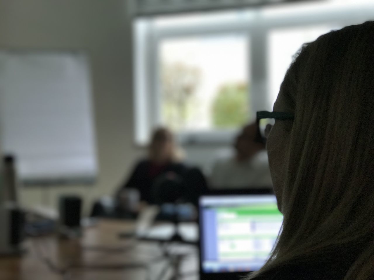 REAR VIEW OF MAN USING MOBILE PHONE IN OFFICE