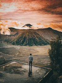 Rear view of man standing against mount bromo